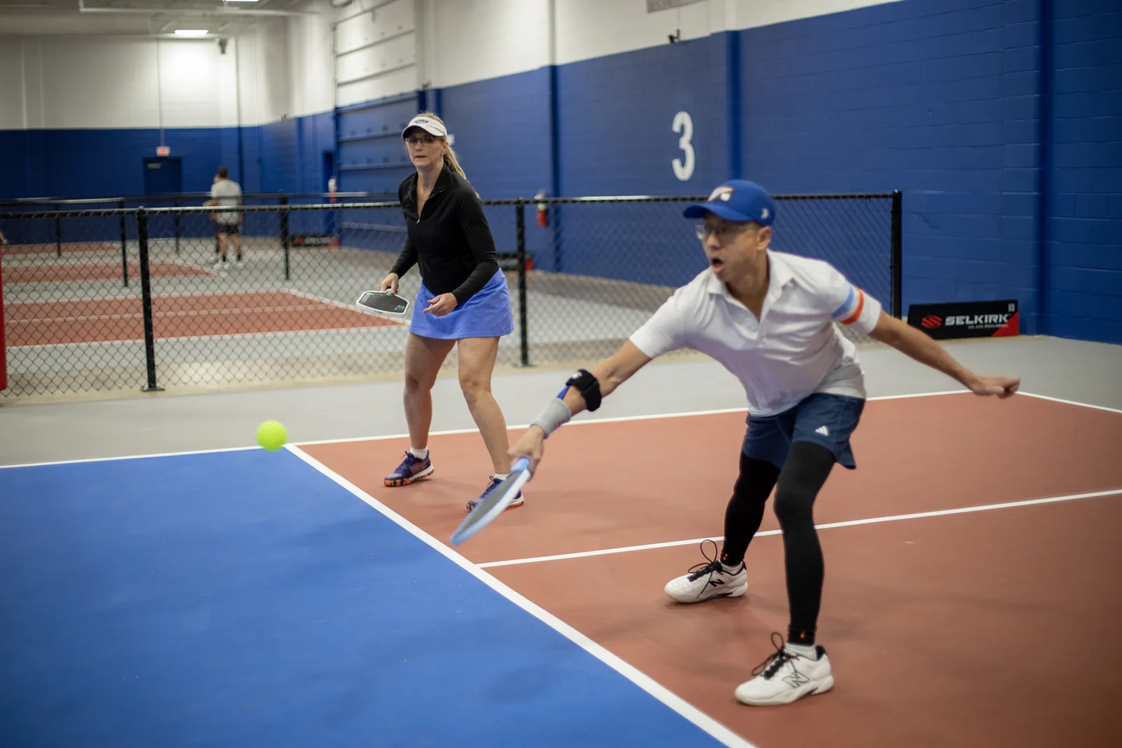 Doubles partners returning a shot on a Jar court